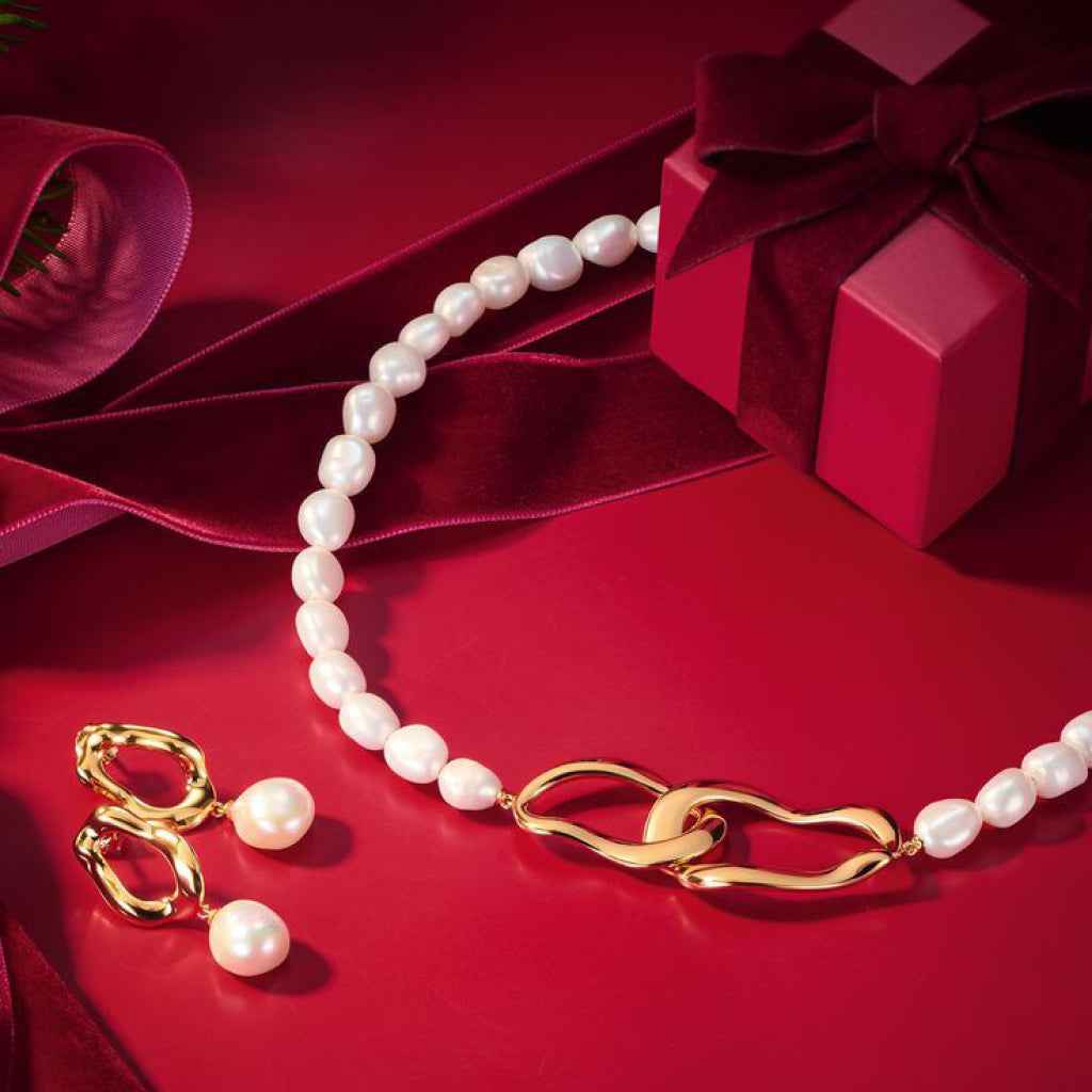 Smiling woman in red beside a gold charm bracelet circle displaying THOMAS SABO Charm Club Valentine's charms including hearts, roses and crystal pendants.