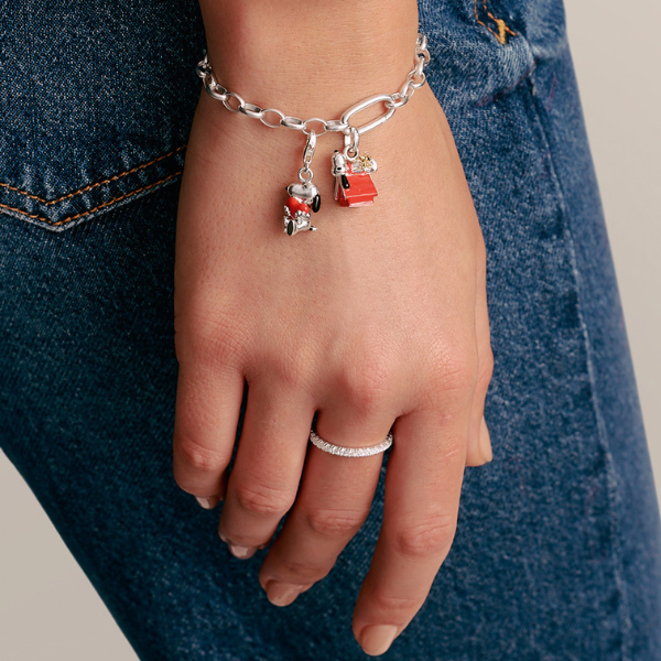 Two hands clasped together wearing THOMAS SABO yellow gold and sterling silver rings, bracelet, and crown pendant necklace; 