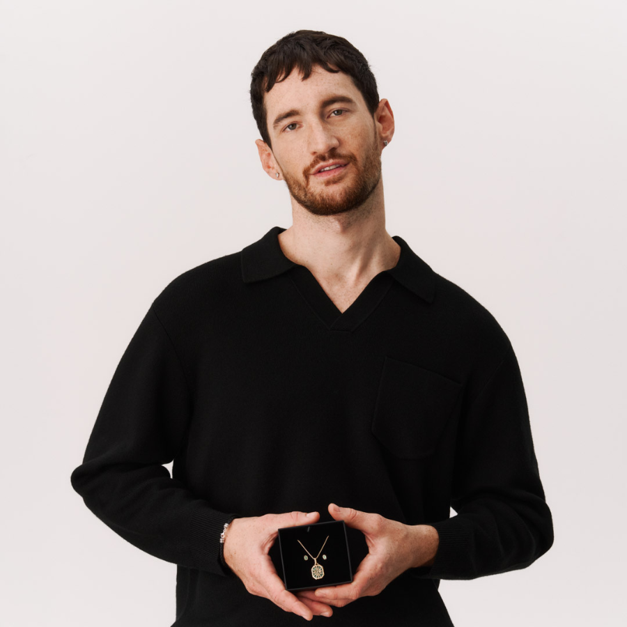 Two hands clasped together wearing THOMAS SABO yellow gold and sterling silver rings, bracelet, and crown pendant necklace; "Together" campaign.