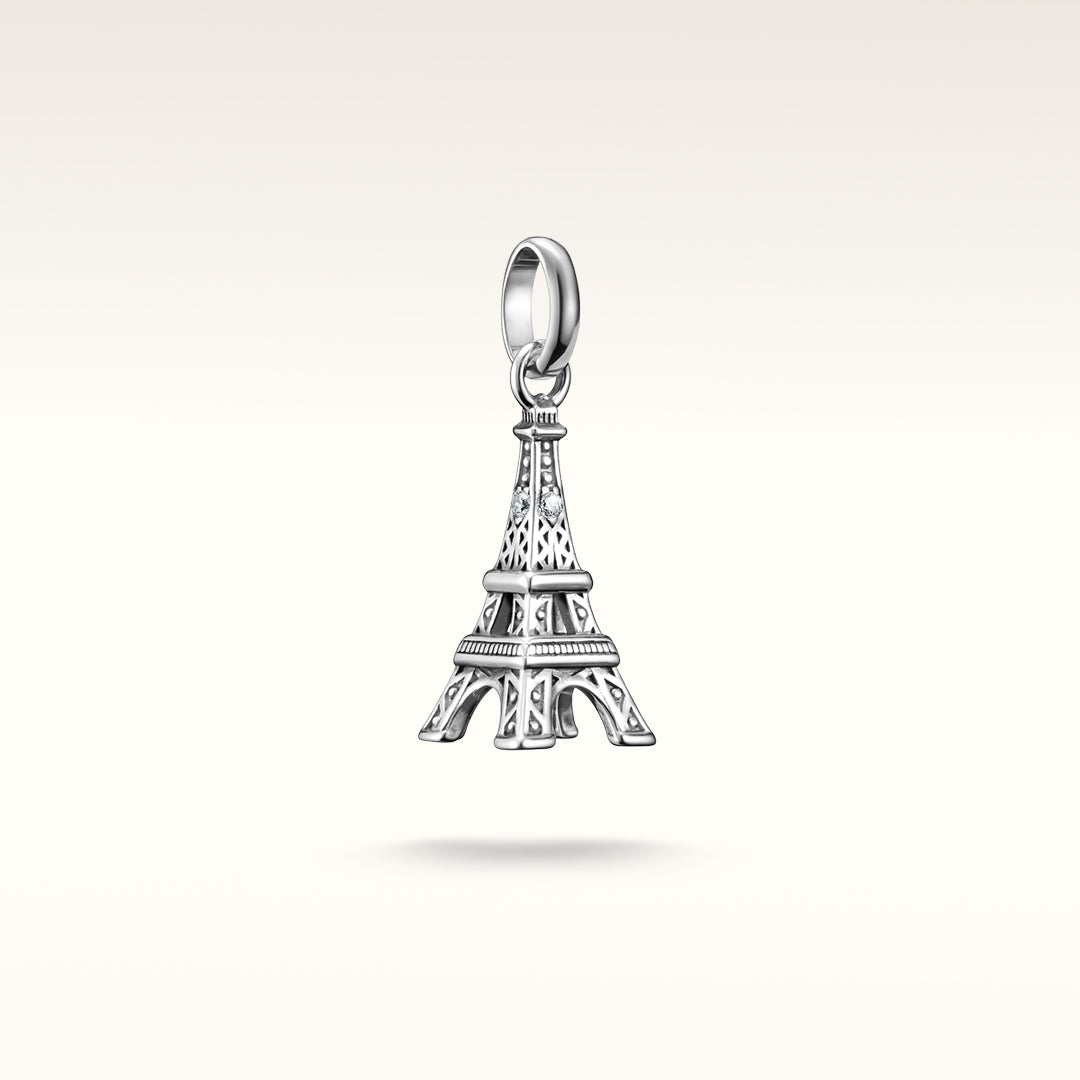 Sterling silver Eiffel Tower charm pendant with filigree detailing and crystal accents, suspended from a bail.
